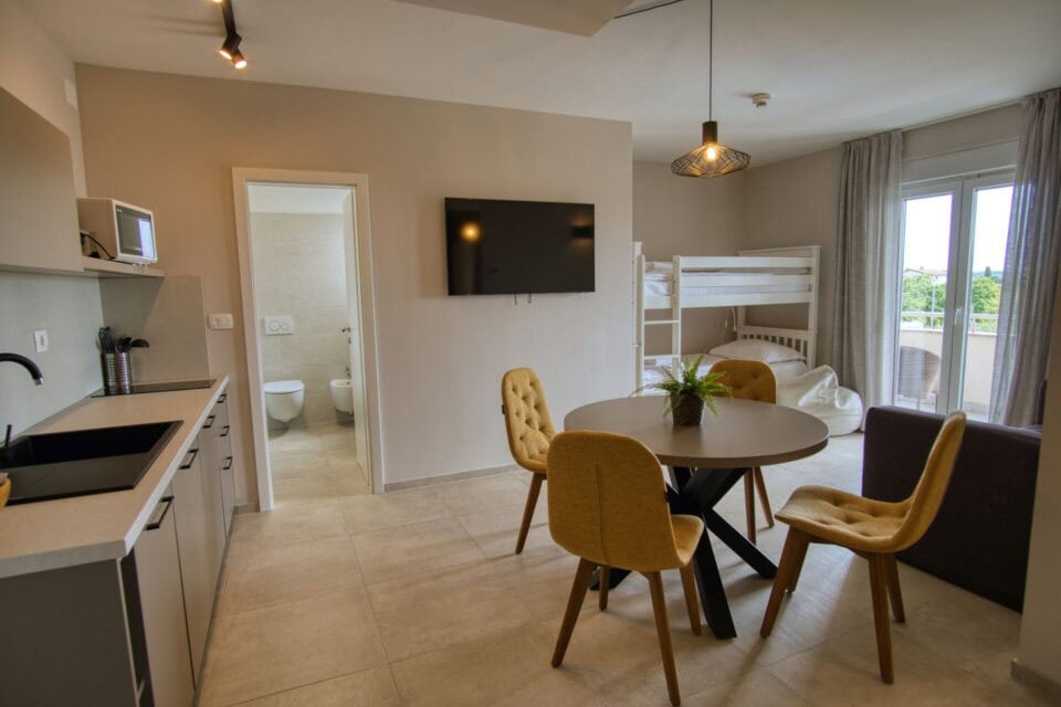 Moderan apartman s kuhinjom i krevetima na kat.