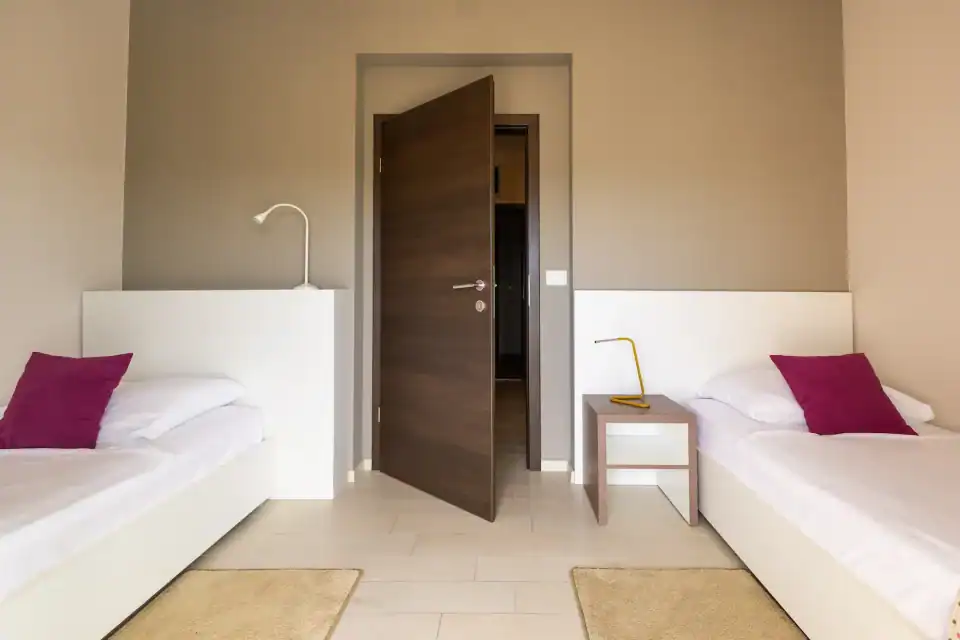 Minimalistička soba s dva odvojena kreveta