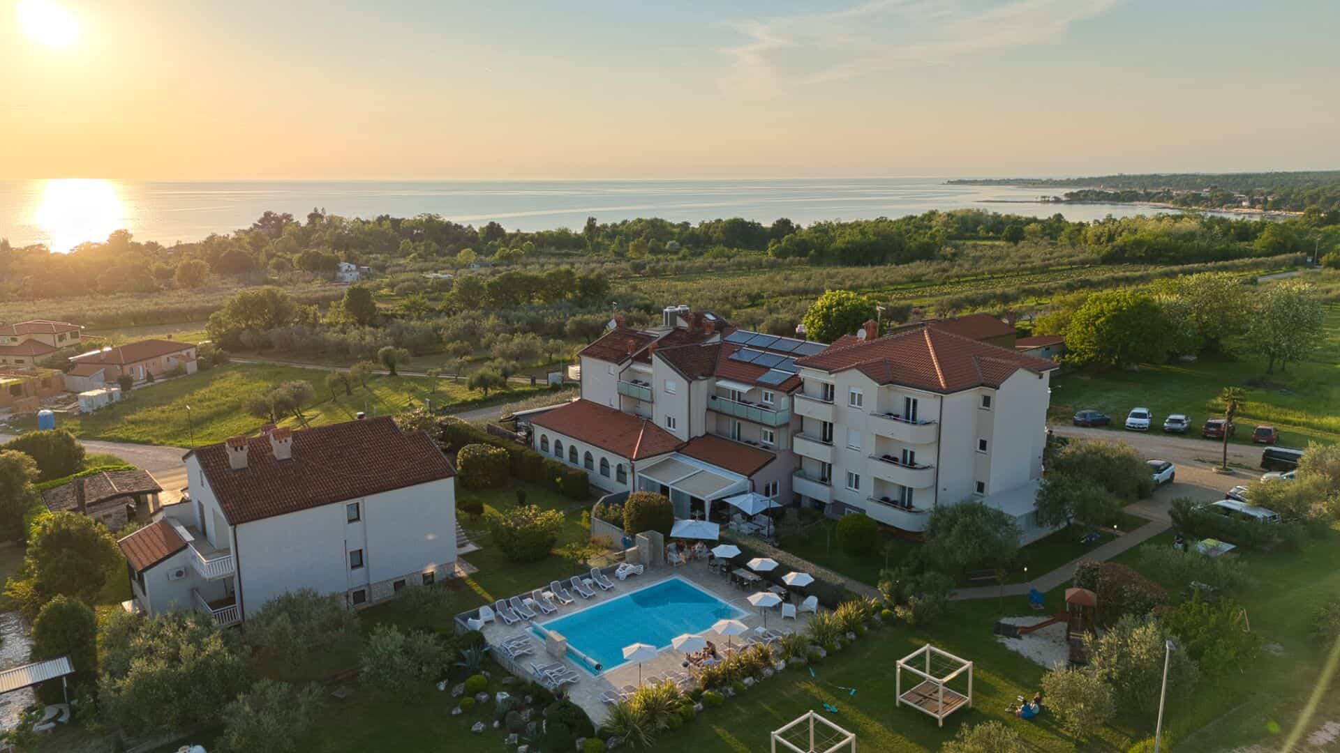 Suncem obasjan hotel s bazenom uz more.