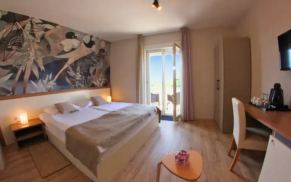 Moderna hotelska soba s bračnim krevetom i balkonom