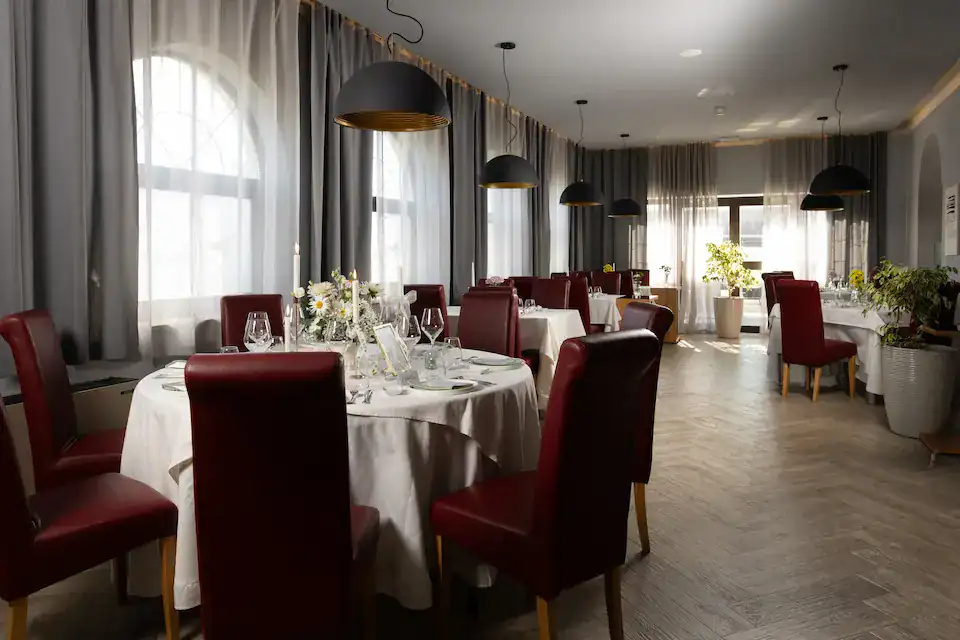 Elegantni restoran s crvenim stolicama i bijelim stolnjacima